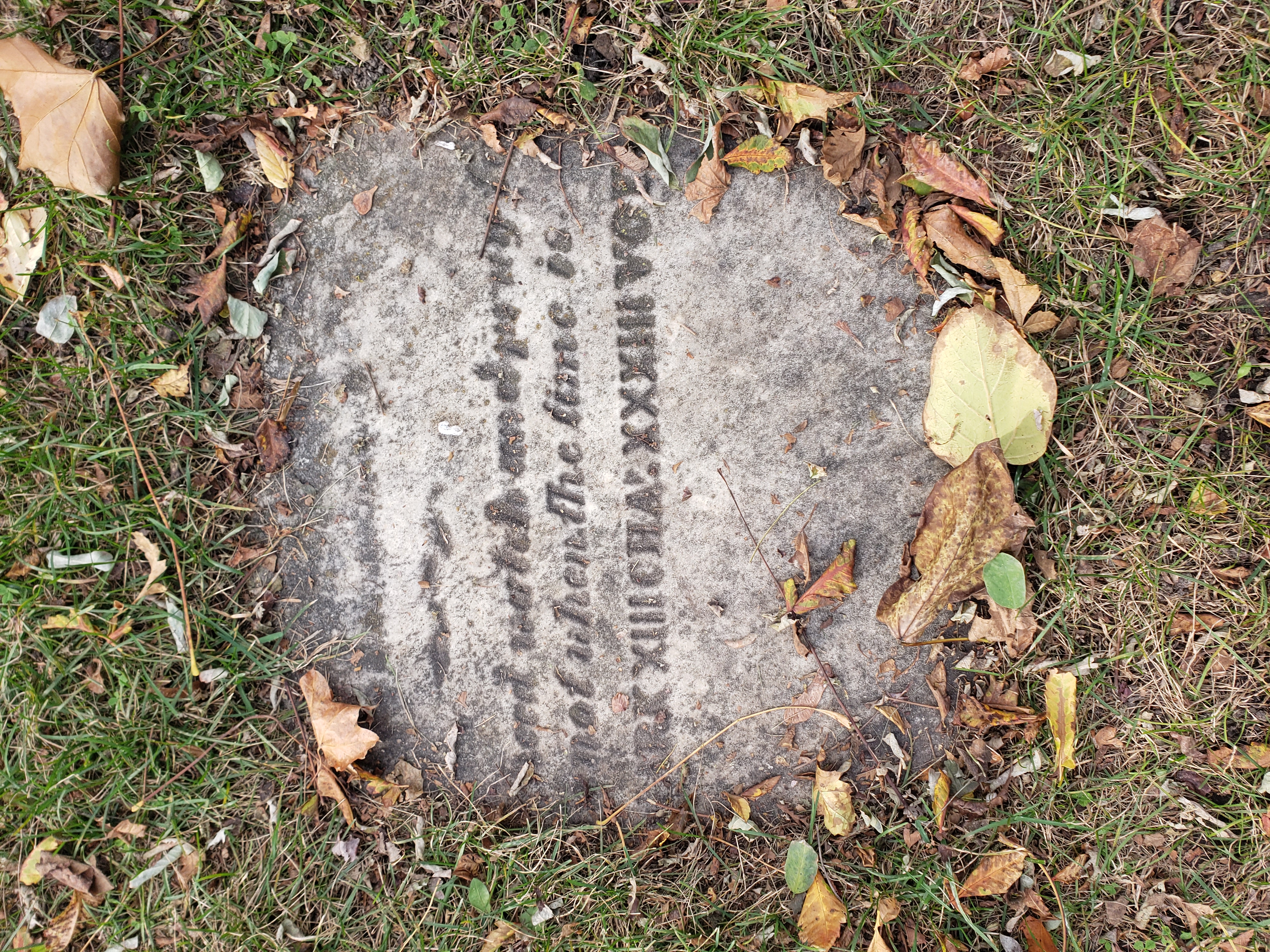 A Half Buried Plaque at the Toronto Necropolis